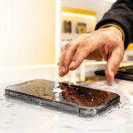 Water damaged smartphone on a repair desk with a technician inspecting the device