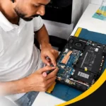 Laptop repair technician working on an open laptop