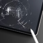 Cracked tablet screen with severe impact damage, illustrating a broken device screen in need of repair 