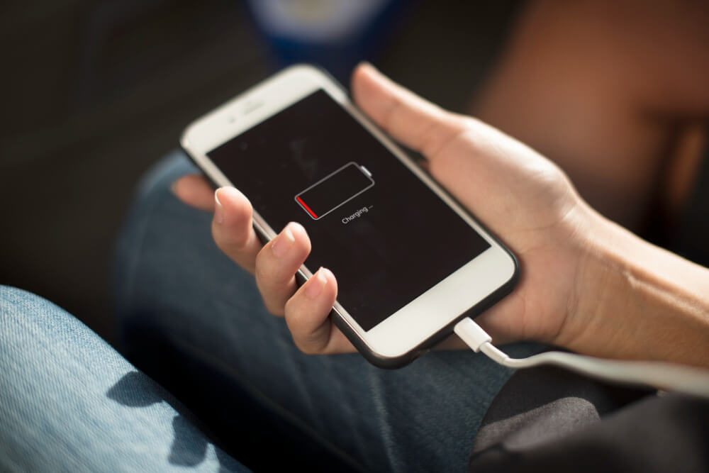 iPhone with low battery connected to a charging cable